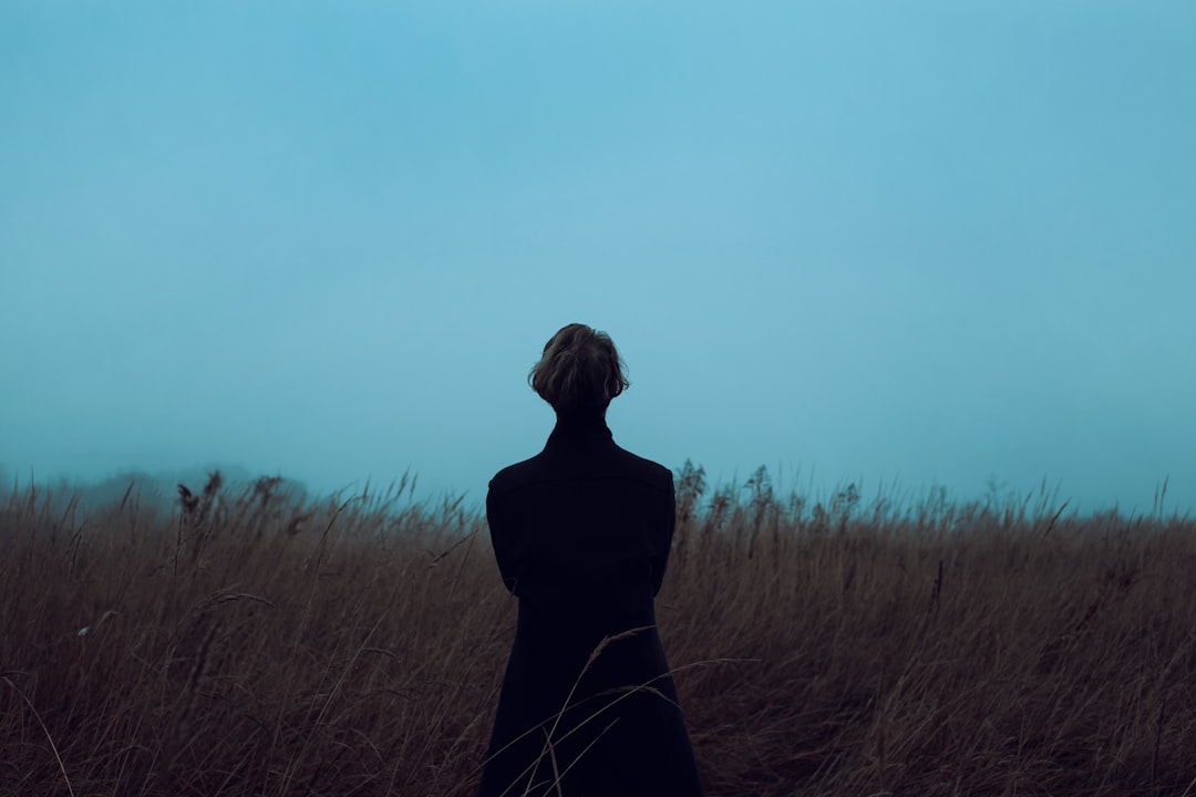 a woman standing in a field of tall grass